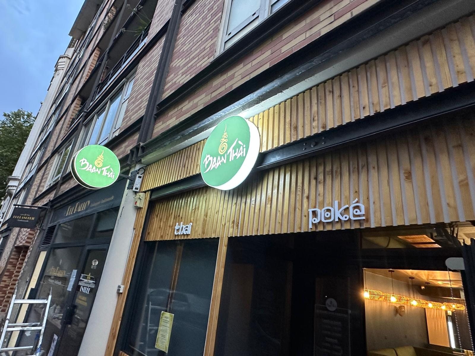 Enseignes drapeau rondes Baan Thai posées en façade