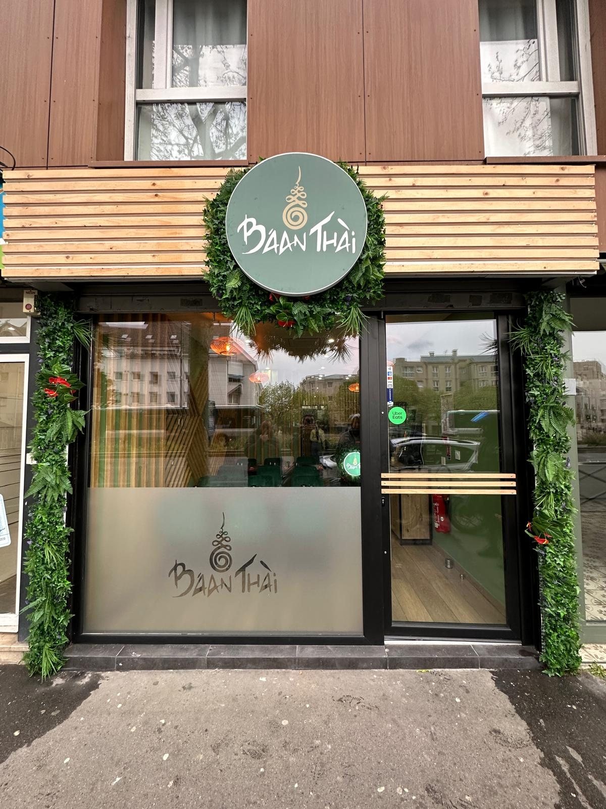 Façade Baan Thai avec enseigne ronde, habillage bois et vitrophanie
